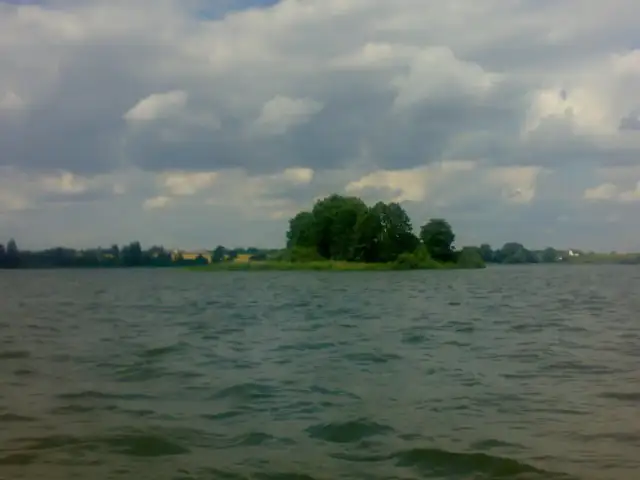 Spokojne jezioro Głuszyńskie, idealne na wędkowanie. Na horyzoncie zielone drzewa i chmury.