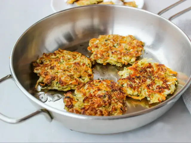 Złociste kotlety wegetariańskie smażą się na patelni. Idealny sposób, jak zrobić kotlety wegetariańskie na obiad.