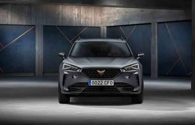 Szary SUV z charakterystycznym logo na grillu. To Cupra, jaka to marka? Sportowy design i nowoczesne linie.
