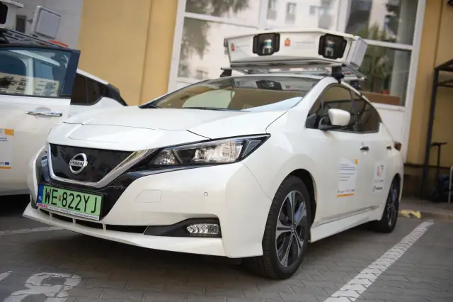 Biały samochód Nissan z zamontowanym na dachu urządzeniem do skanowania.