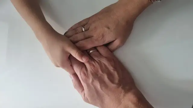 Dłonie dziecka i rodziców splecione razem. Nadzieja na powrót do domu, jak odzyskać dzieci z domu dziecka.