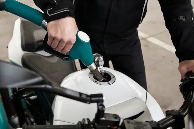 Tankowanie białego motocykla. Zastanawiasz się, ile pali motor 125?