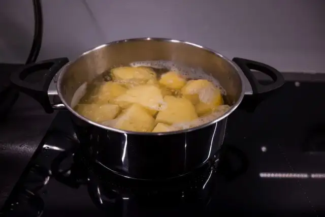 Gotowane ziemniaki w garnku, gotowe do przygotowania pysznej sałatki ziemniaczanej.