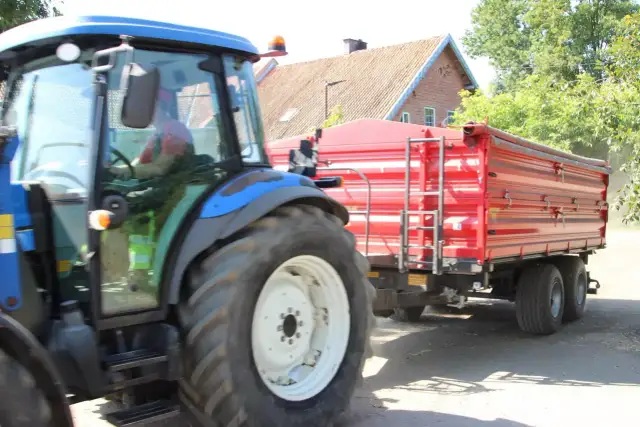 Kierowca w kabinie traktora z przyczepą. Czy na kat B można jeździć ciągnikiem z przyczepą? To pytanie nurtuje wielu rolników.