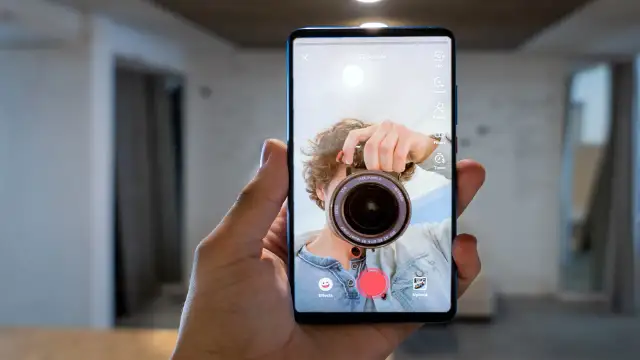 Zrzut ekranu telefonu z aplikacją do nagrywania wideo. Mężczyzna robi sobie selfie z aparatem.