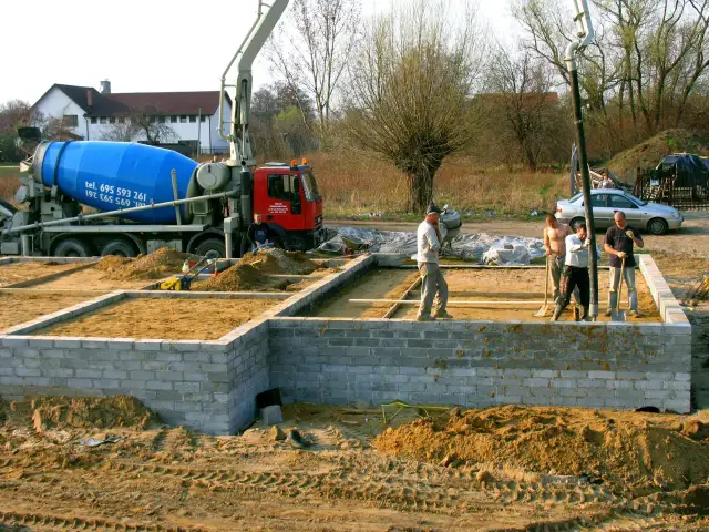 Budowa fundamentów: betonowóz i ekipa przygotowują teren. Czym obsypać fundamenty? Piaskiem i żwirem.