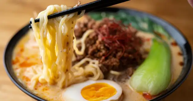 Jak zrobić ramen z zupki chińskiej? Miska pełna pysznego ramenu z makaronem, mięsem mielonym, jajkiem i warzywami.