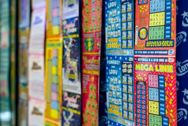 Rząd kolorowych zdrapek loteryjnych z widocznymi nagrodami i symbolami.