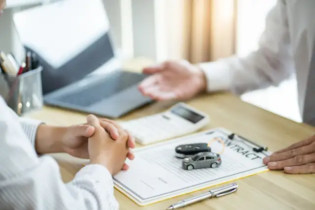 Na stole leżą dokumenty, kluczyki do auta i kalkulator. To wszystko, co jest potrzebne do przerejestrowania samochodu.