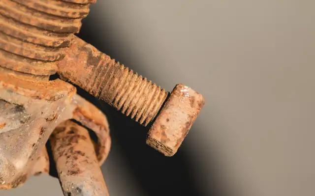 Zardzewiała śruba z gwintem. Aby ją odkręcić, należy ją przekręcić w lewo.