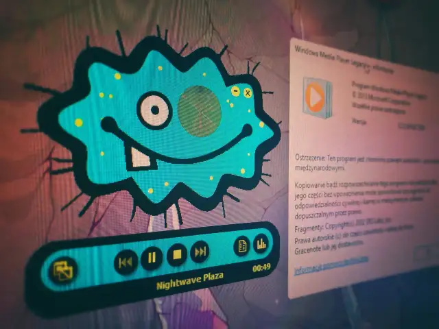 Niebieski, kreskówkowy wirus z uśmiechem i zębem, obok okna z informacjami o Windows Media Player.