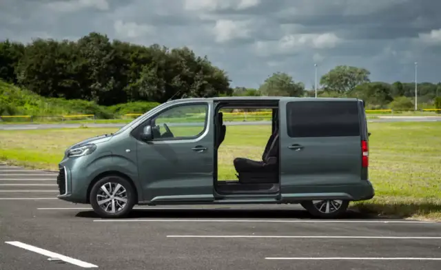 Zielony bus 9 osobowy z otwartymi drzwiami, idealny na rodzinne wycieczki. Jaki wybrać?