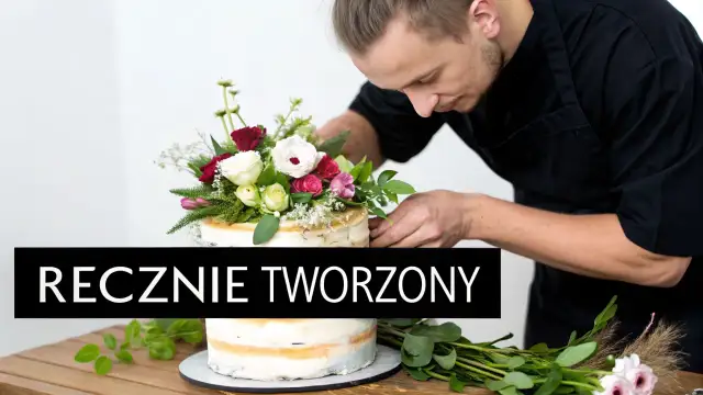 Mistrz cukiernictwa dekoruje tort z kwiatami żywymi, tworząc dzieło sztuki.