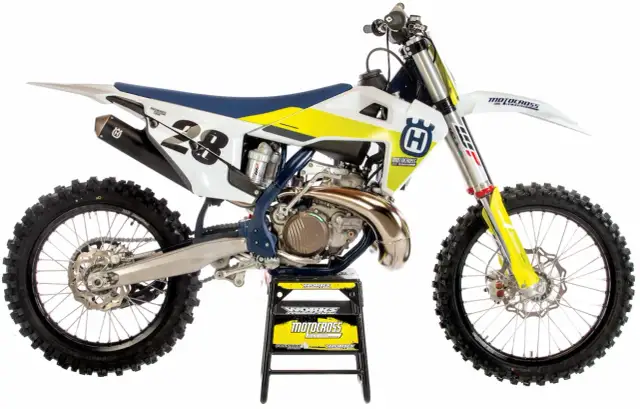Motocykl Husqvarna 250 Enduro z numerem 28, biało-żółty, na czarnym stojaku.