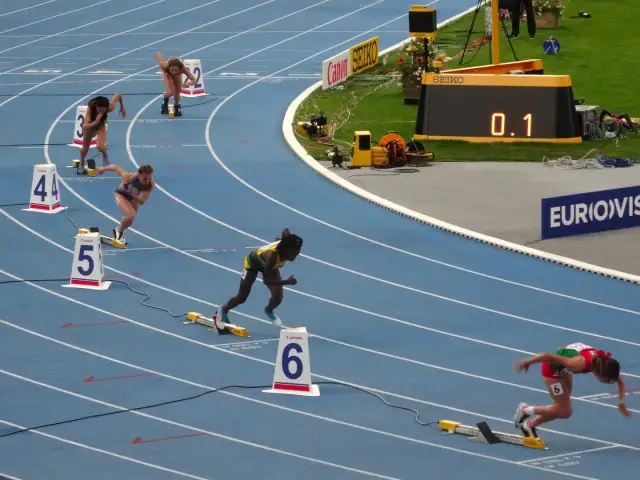 Biegaczki na 400 m, jedna z nich w zielono-żółtym stroju, walczy o rekord Polski.