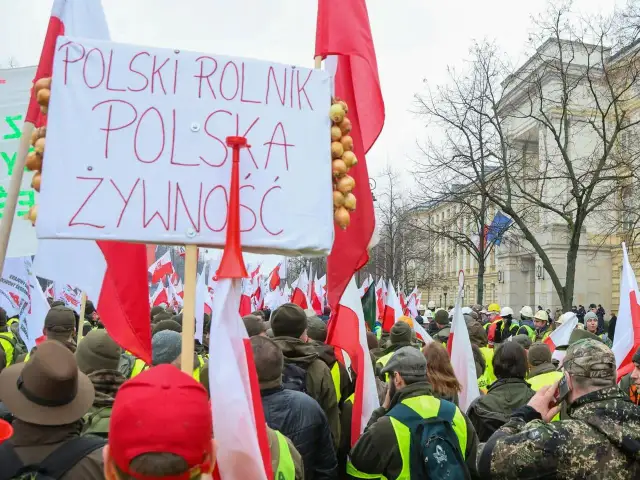 Rolnicy protestują przeciwko zielonemu ładowi, domagając się polskiego rolnika i polskiej żywności. Transparent z cebulami i flagi Polski.