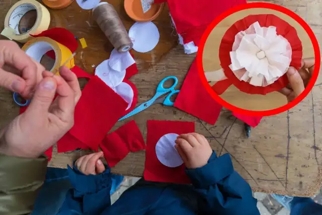 Dzieci tworzą kotyliony z czerwonego i białego materiału, przygotowując się do nauki, jak przypiąć kotylion do bluzki.