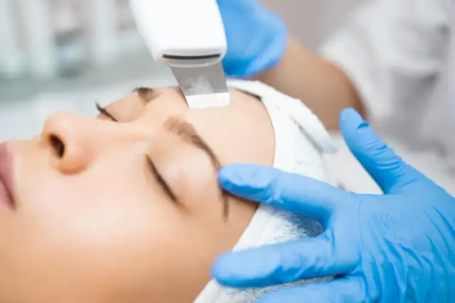 Kobieta poddana zabiegowi peelingu kawitacyjnego na twarz.