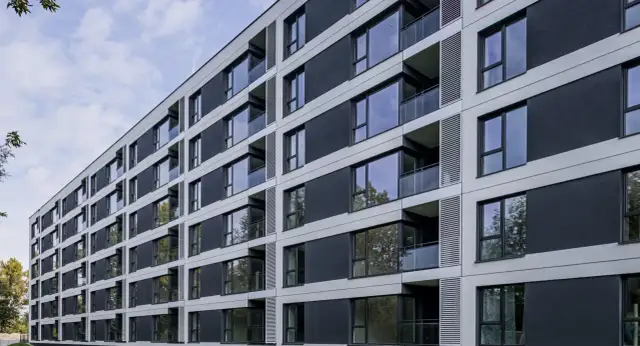 Nowoczesny blok mieszkalny z balkonami i dużymi oknami. Czy mieszkanie komunalne można wynająć w takim miejscu?