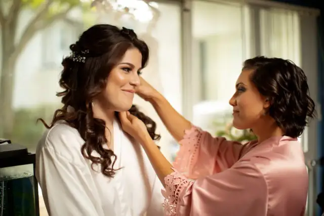 Dwie kobiety w szatach, jedna poprawia włosy drugiej.