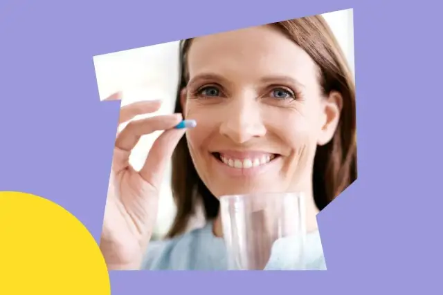 Uśmiechnięta kobieta bierze kapsułkę. Magnez na co pomaga? Na dobre samopoczucie i energię.