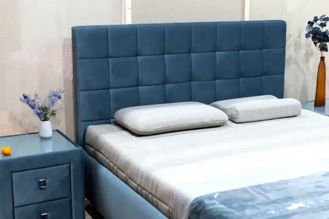 Elegancki, tapicerowany zagłówek do łóżka w kolorze niebieskim. Dowiedz się, jak zamontować zagłówek do łóżka, by stworzyć przytulną sypialnię.