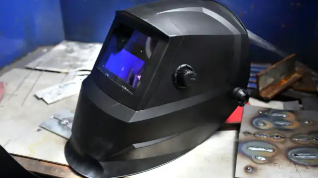 Czarna maska spawalnicza samościemniająca, gotowa do pracy. Dowiedz się, jak ustawić ją dla optymalnej ochrony.