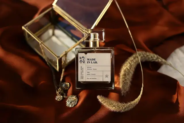 Elegancka butelka perfum "Made in Lab" na satynowym tle. Zastanawiasz się, co dłużej pachnie: woda toaletowa czy perfumowana?