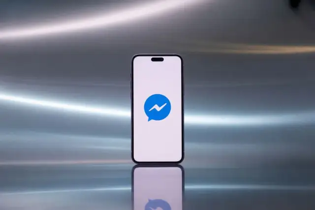 Smartfon z ikoną Messengera. Dowiedz się, jak sprawdzić zablokowane osoby na Messengerze.