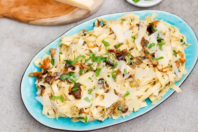 Tagliatelle z grzybami, posypane parmezanem i natką pietruszki. Pyszny przepis na makaron z leśnymi grzybami.
