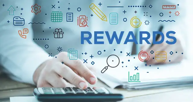 System sugestii pracowniczych. Ręce na kalkulatorze, słowo REWARDS i ikony symbolizujące pracę i nagrody.