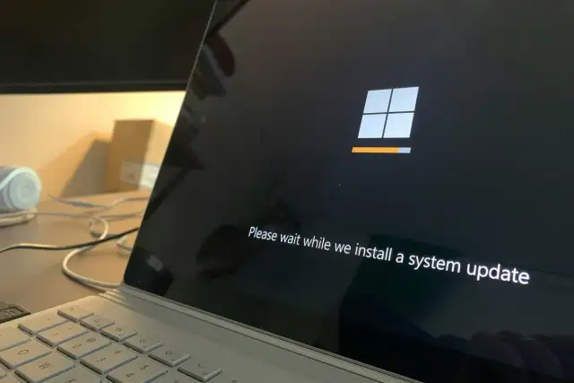 Ekran laptopa z logo Windows i paskiem postępu. System Windows 10 LTSC instaluje aktualizację.