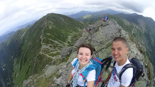 Uśmiechnięci turyści na szczycie w Tatrach Zachodnich Słowacja. Widok na górzyste krajobrazy i szlak.