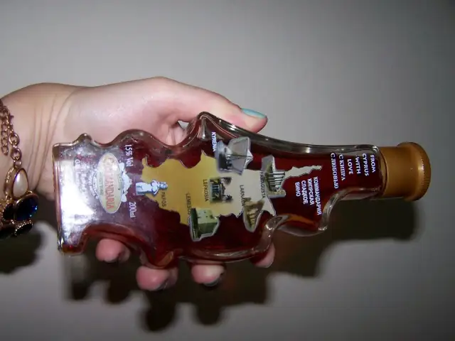 Butelka Commandaria, słodkiego wina z Cypru, z mapą wyspy i nazwami miast. Idealny pomysł, co warto przywieźć z Cypru.