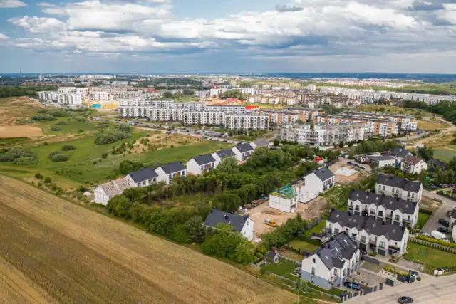 Nowe osiedle domów i bloków mieszkalnych, bliskość natury i infrastruktury miejskiej. Plusy mieszkania w mieście.
