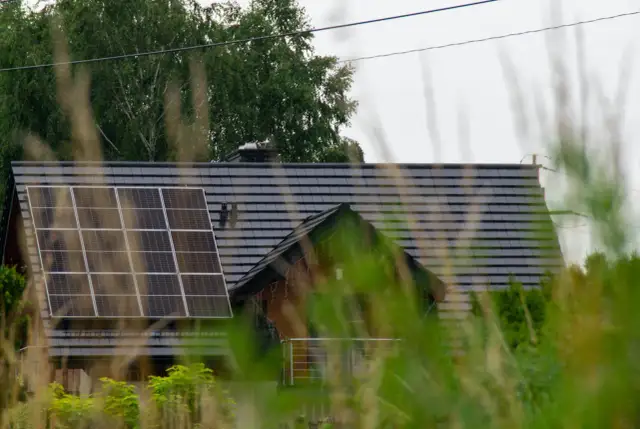 Dach domu z panelami fotowoltaicznymi, które wyglądają na instalację fotowoltaiczną bez zgłoszenia.