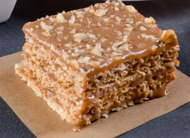 Warstwowe wafle z kremem kajmakowym, posypane orzechami. Pyszny deser, który rozpływa się w ustach.