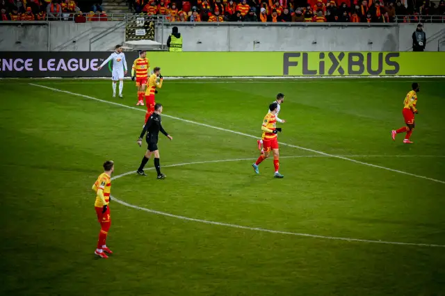 Piłkarze w czerwono-żółtych strojach na boisku. Kto wymyślił piłkę nożną? To pytanie pozostaje bez odpowiedzi, ale gra trwa!