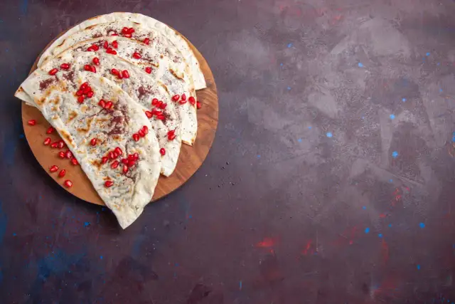 Plastry tortilli z granatem i przyprawami, idealne, by dowiedzieć się, jak podgrzać tortillę, żeby była miękka.