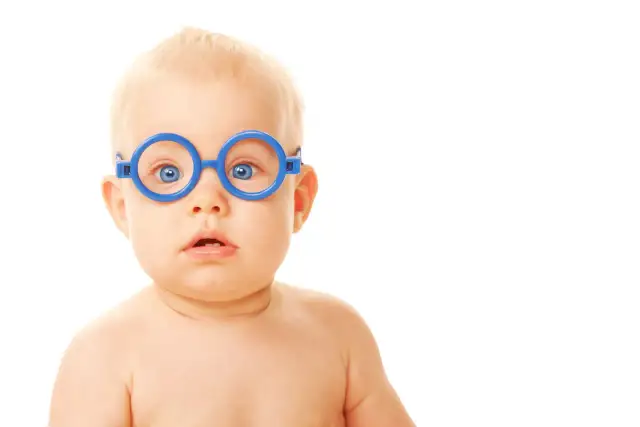 Niebieskie okulary na nosie niemowlaka, który ma lekki zez.