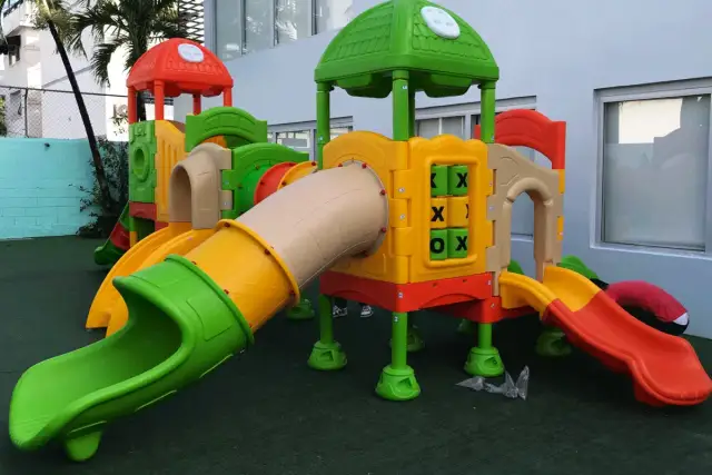 Kolorowy plac zabaw z rurami, zjeżdżalniami i grą kółko-krzyżyk.