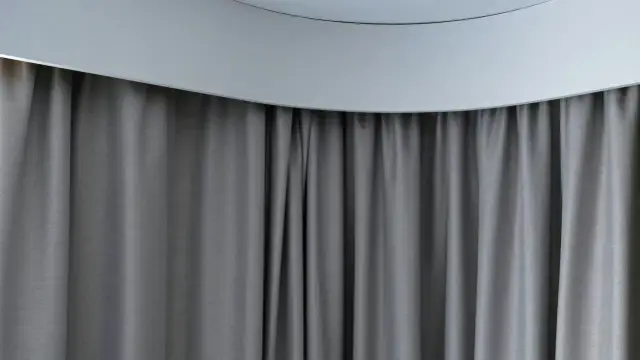 Szare zasłony pięknie maskują karnisz, tworząc elegancką i spójną całość.