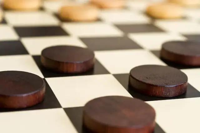 Drewniane pionki do gry w warcaby na planszy.