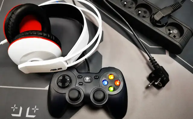 Słuchawki gamingowe, pad Logitech i listwa zasilająca - wszystko gotowe do gry. Zastanawiasz się, ile prądu ciagnie komputer gamingowy?