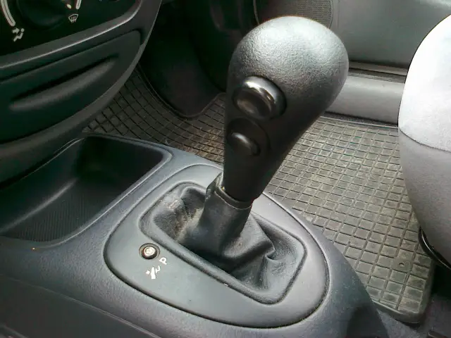 Do czego służy przycisk umieszczony na dźwigni zmiany biegów? Zaskakujące funkcje!