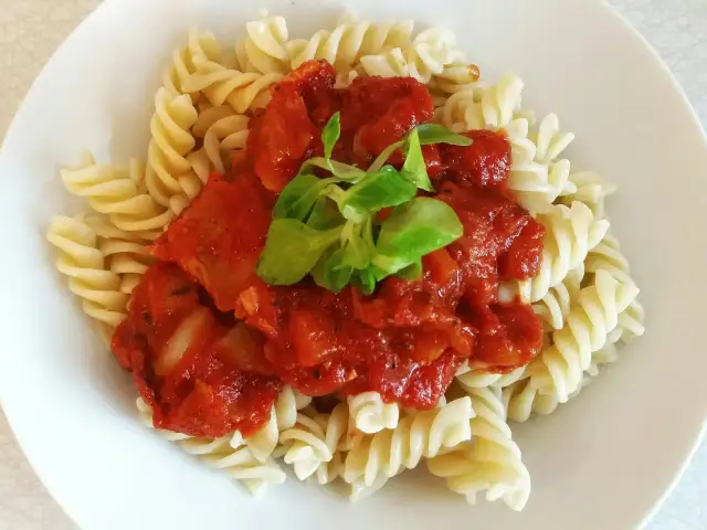 Fusilli z bogatym sosem passata pomidorowa, ozdobione świeżą zieleniną. Pyszne danie, które zadowoli każdego miłośnika włoskich smaków.