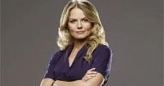 Jennifer Morrison, znana z filmów, seriali i programów, prezentuje się pewnie z rękami skrzyżowanymi na piersi.