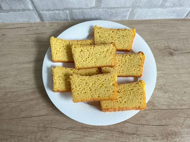 Chleb bezglutenowy z mąki kukurydzianej, pokrojony w kromki, ułożony na białym talerzu. Pyszny przepis!