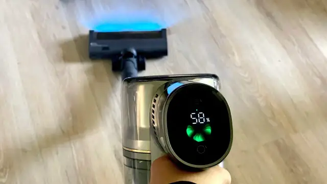 Odkurzacz Dreame z ekranem pokazującym 58% baterii i niebieskim światłem na szczotce. Dreame to firma znana z innowacyjnych rozwiązań.