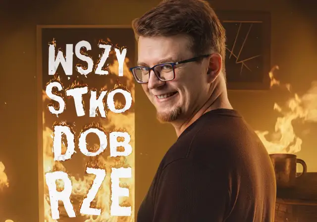 Mieszko stand up w płomieniach, z napisem "WSZYSTKO DOBRZE". Uśmiechnięty mężczyzna w okularach na tle ognia.